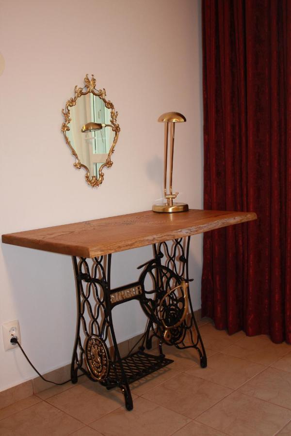 A small table on a sewing-machine base, with a gilded mirror